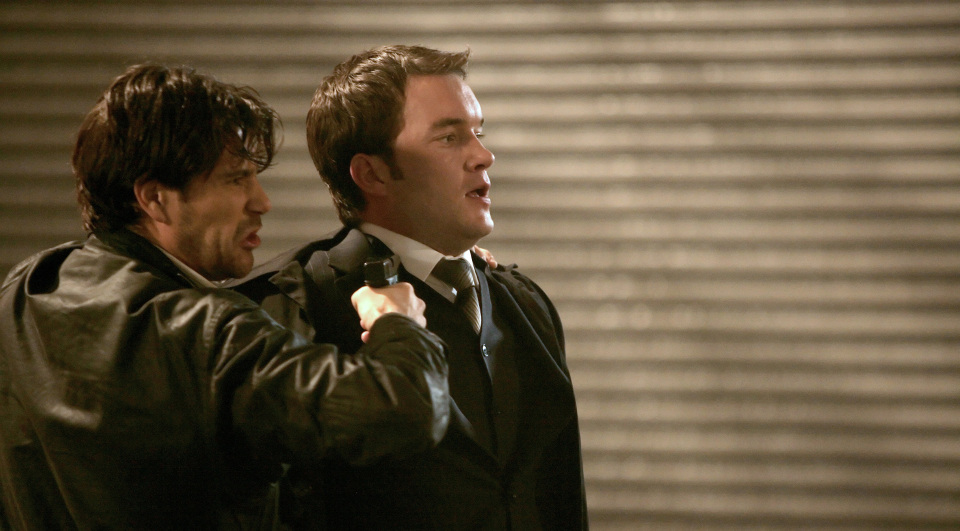 Dale (Matt Ryan, l) bedroht Ianto (Gareth David-Lloyd) mit einer Waffe.