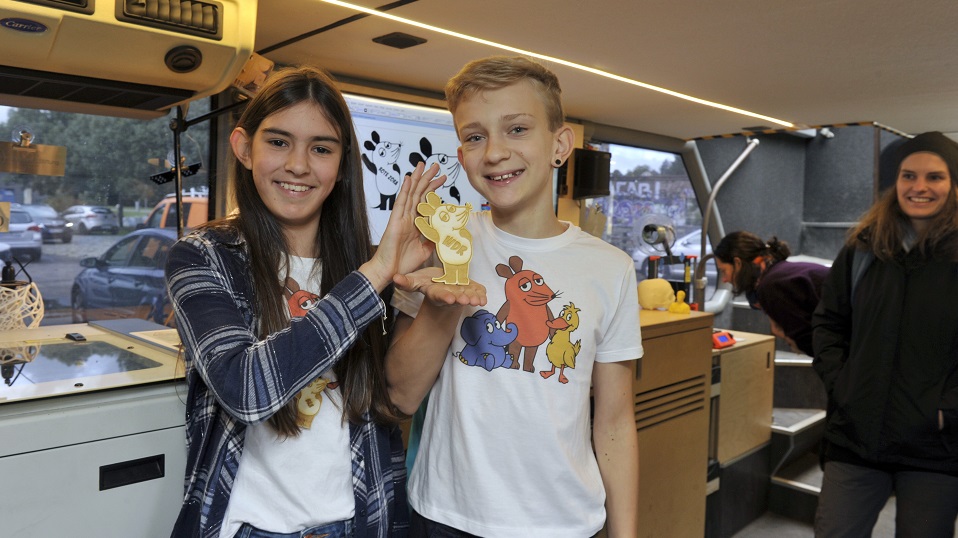 In einem Doppeldeckerbus voller Kunst und Technik machen die "Maus-Kinder" viele Entdeckungen. Bea und Oskar haben mit dem Laser eine Maus aus Holz ausgeschnitten. | Bildquelle: WDR/Axel Berger In einem Doppeldeckerbus voller Kunst und Technik machen die "Maus-Kinder" viele Entdeckungen. Bea und Oskar haben mit dem Laser eine Maus aus Holz ausgeschnitten.