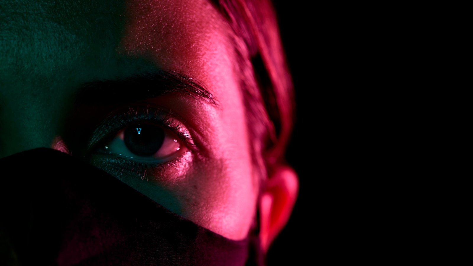 Eine Frau trägt eine schwarze Maske, nur ihre Augen sind zu sehen. | Bildquelle: picture alliance / Zoonar / lev dolgachov Eine Frau trägt eine schwarze Maske, nur ihre Augen sind zu sehen.