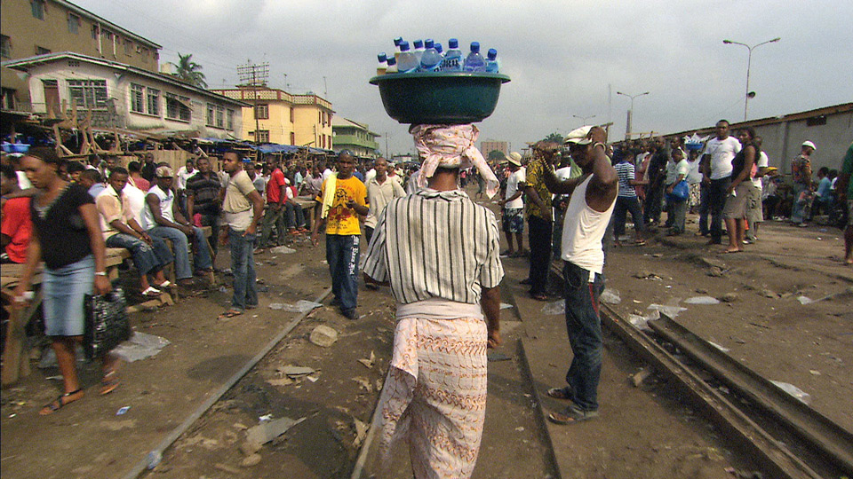 Nigeria: Wasserverkäuferin trägt PET-Wasserflaschen auf dem Kopf | Bildquelle: WDR/DokLab GmbH Nigeria: Wasserverkäuferin trägt PET-Wasserflaschen auf dem Kopf