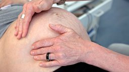 Hebamme tastet Bauch einer Schwangeren ab | Bildquelle: dpa Hebamme tastet Bauch einer Schwangeren ab