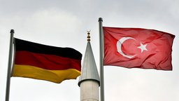 Eine deutsche und eine türkische Fahne wehen vor dem Minarett einer Moschee | Bildquelle: dpa/Berg Eine deutsche und eine türkische Fahne wehen vor dem Minarett einer Moschee