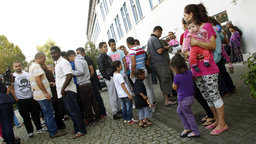 Flüchtlinge versammeln sich vor der Flüchtlingsunterkunft | Bildquelle: WDR / dpa Flüchtlinge versammeln sich vor der Flüchtlingsunterkunft