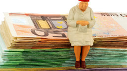 Seniorin sitzt auf Geldscheinen