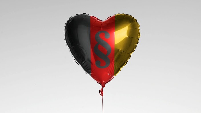 herzförmiger Luftballon in den Farben schwarz, rot, gold und Paragraphenzeichen