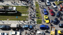 Foto einer Kreuzung, auf der Chaos durch Autos, Fußgänger, Straßenbahnen