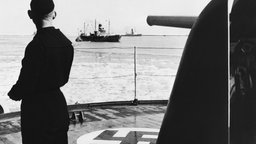 Soldat beobachtet ein Schiff der deutschen Kriegsmarine im Hafen von Kopenhagen