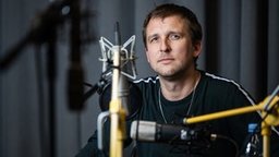 Der Autor Boris Nikitin sitzt während der Aufnahmen vor einem Mikro. | Bildquelle: Oscar Alessio (SRF) Der Autor Boris Nikitin sitzt während der Aufnahmen vor einem Mikro.