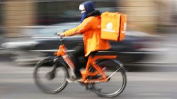 Ein Fahrradbote von Lieferando fährt durch die Stadt